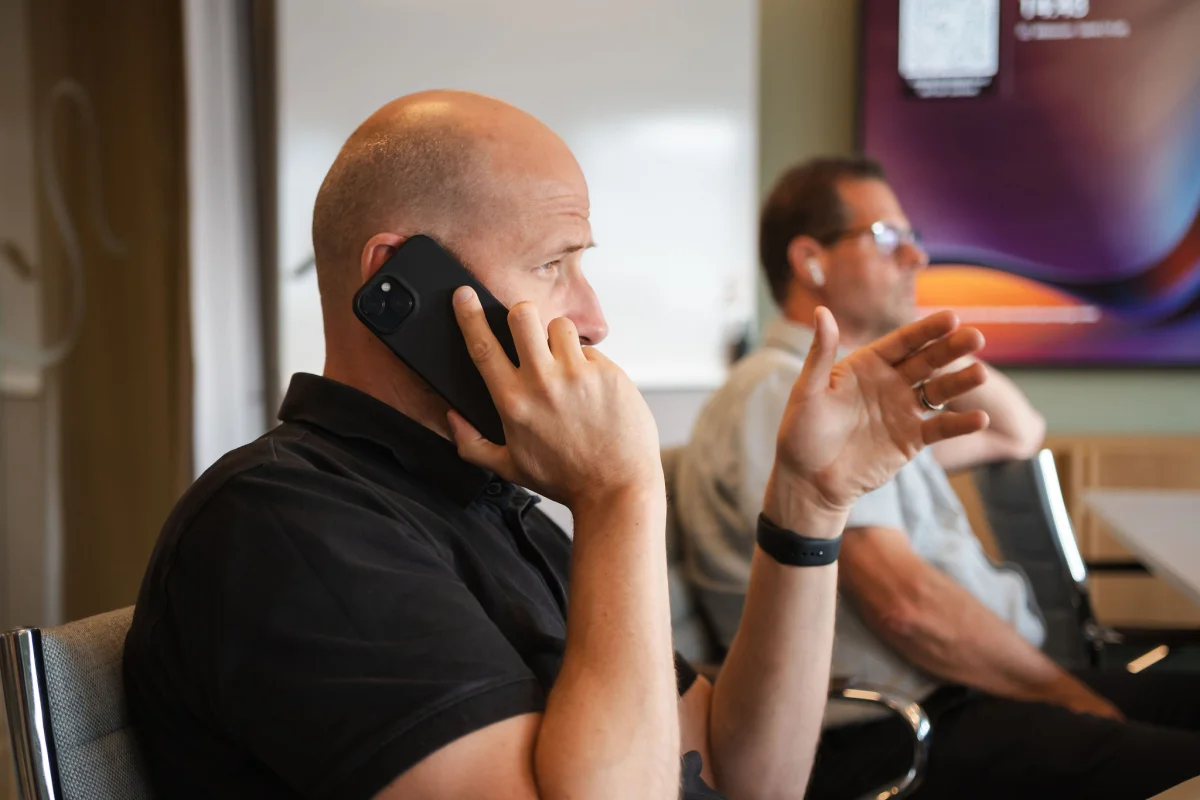 En medarbetare talar i telefon vid sin arbetsplats.